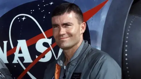 NASA Fred Haise smiles as he stands in front of a Nasa training jet