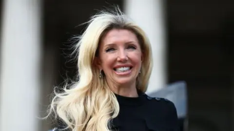 Getty Images A middle-aged woman with bright blonde hair. She is wearing a black top. 