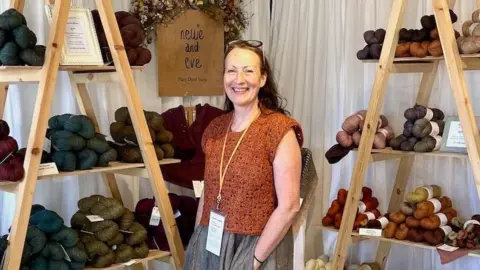 Helen Hickman Helen stands surrounded by wool from her business