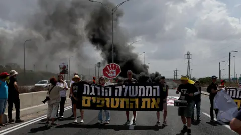 EPA Protesters next to burning tires on the main road at Petah Tikva, Israel