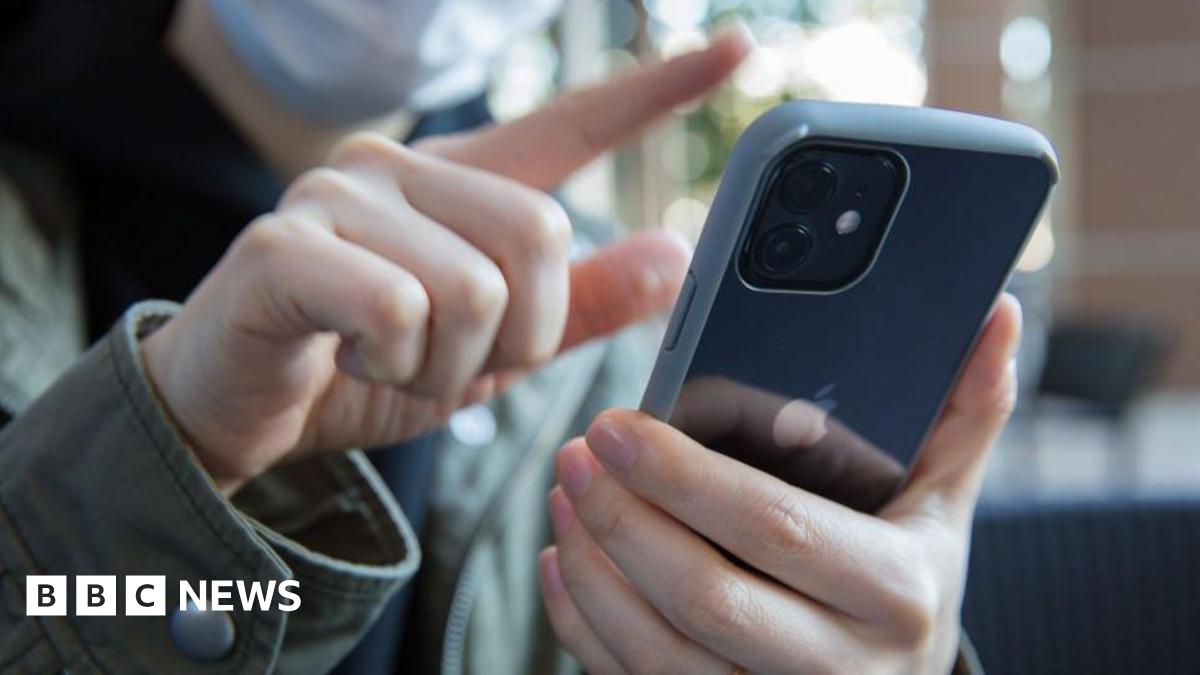 In this photo illustration, a woman swipes with her finger on the screen of an iPhone.