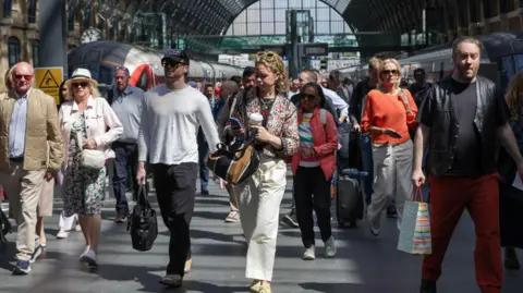 Getty Images A group of people walk through King's Cross Station in London. 