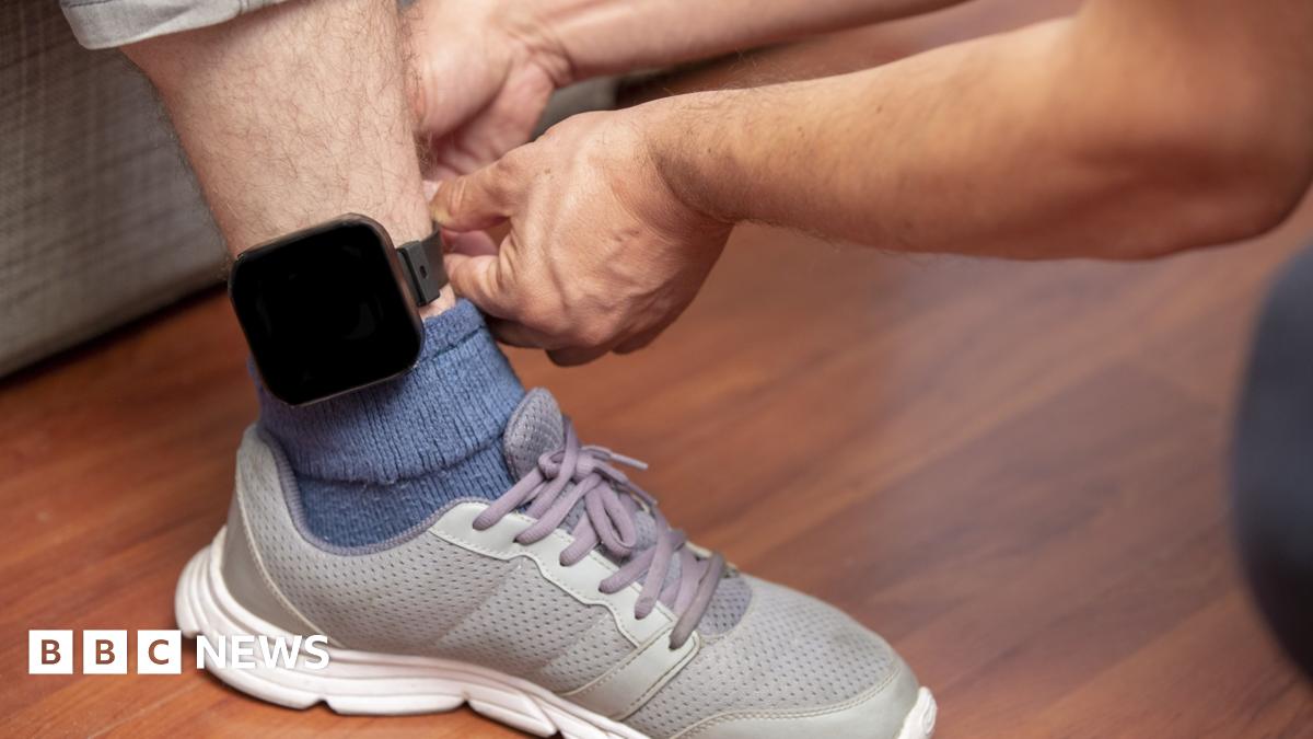 A male foot is fitted with a monitoring ankle bracelet.