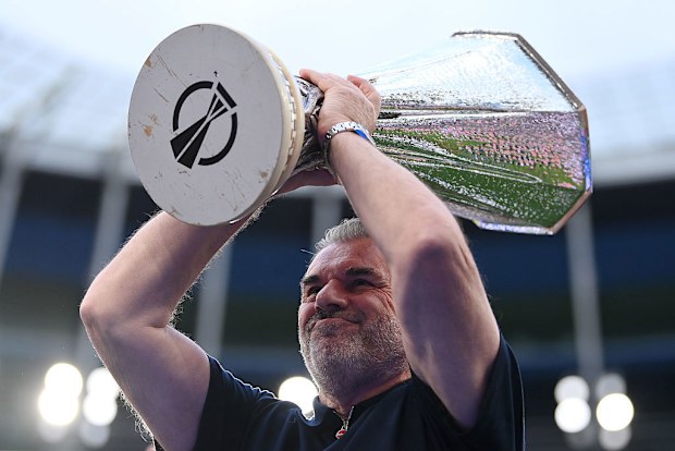 Ange Postecoglou lifts the Europa League trophy as he acknowledges the fans.