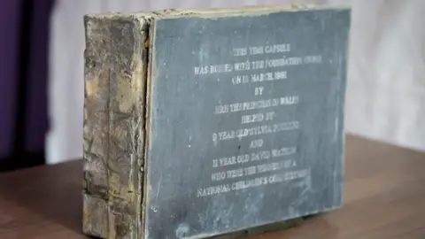 Great Ormond Street Hospital for Children A lead-encased wooden box is on the table. On the outside, there is information written about the date of its burial. 