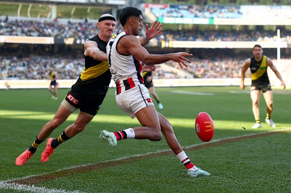 Nasiah Wanganeen-Milera of the Saints kicks the ball under pressure from Kamdyn McIntosh of the Tigers.
