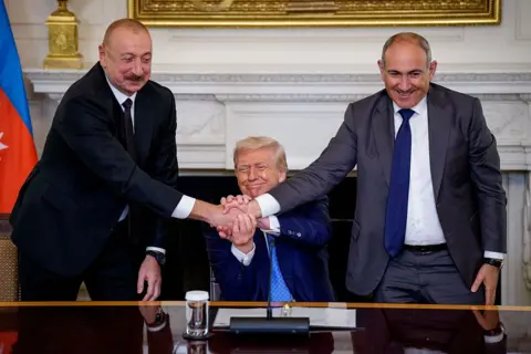 Getty US President Donald Trump joins hands with Azerbaijani President Ilham Aliyev and Armenian Prime Minister Nikol Pashinyan during a signing ceremony in the State Dining Room of the White House on August 8, 2025 in Washington, DC. 