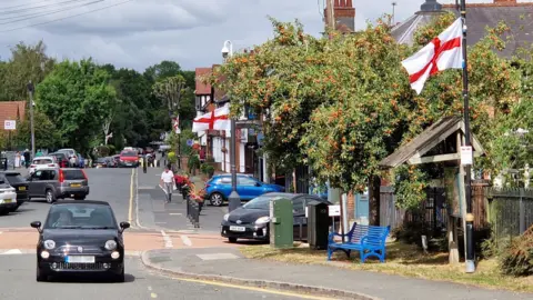 BBC Barnt Green High Street, with England flags hung from the poles on the side of the road.