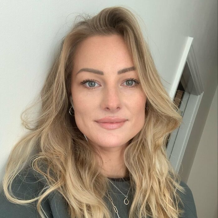 Close-up of a woman with blonde hair, wearing a dark top, representing a 15,500-ft jump after breakup story.