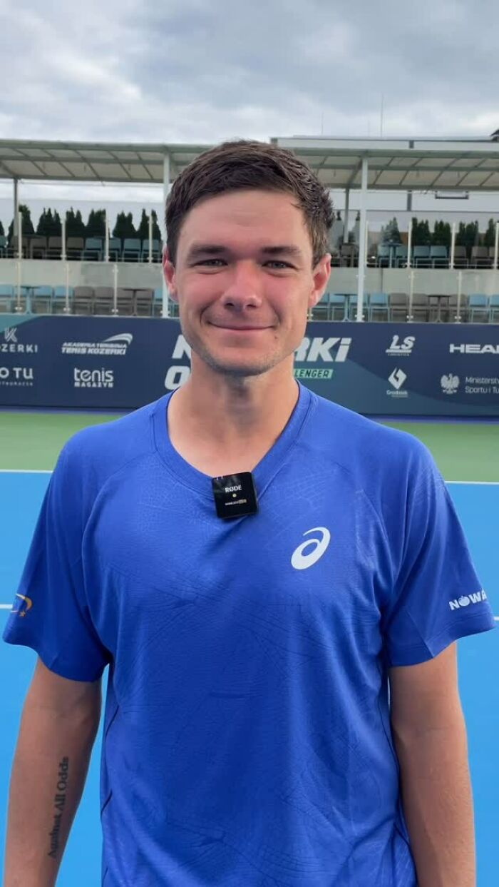 Young man in a blue shirt on a tennis court, related to US Open hat snatcher and Polish CEO news.