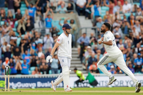 England's Gus Atkinson walks off the pitch after losing his wicket to Mohammed Siraj.