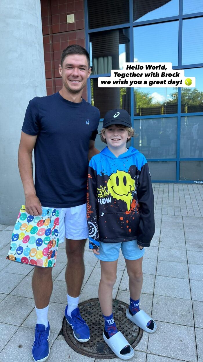 Polish CEO posing with a young fan outside a building, related to the infamous US Open hat snatcher incident.
