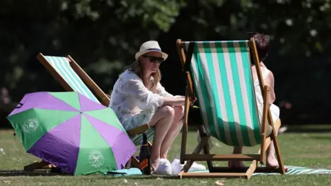 EPA Londoners enjoy the warm weather at a park in London