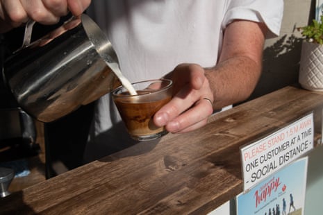 Someone wearing a white T-shirt makes a coffee