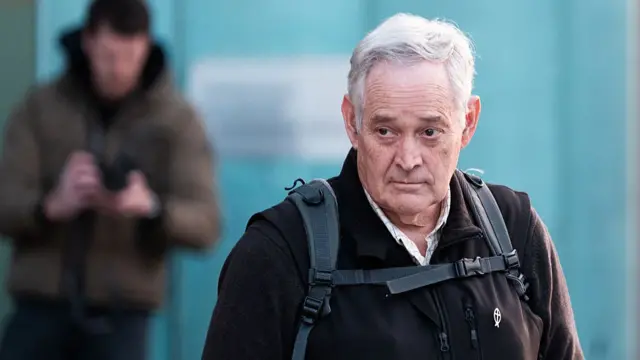 Ian Wilkinson wearing a backpack and a black jacket