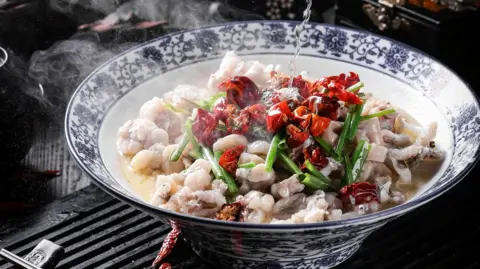 Getty Images A piping hot Sichuan dish made of fish slices in a hot and sour broth, topped with dried chilli and spring onion 