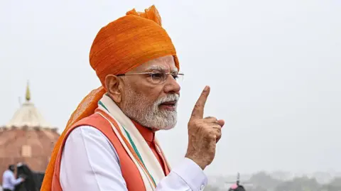 Bloomberg via Getty Images Narendra Modi, India's prime minister, wearing a bright saffron turban, points to crowds during the nation's Independence Day ceremony at Red Fort in New Delhi, India, on Friday, 15 August, 2025. 