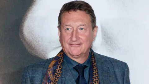 Getty Images Steven Knight in a smart suit and scarf