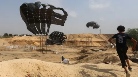 Reuters A Palestinian boy runs to gather aid packages which have been dropped by Indonesia. 