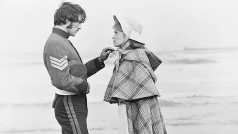 Getty Images Terence Stamp and Julie Christie - as Sergeant Troy and Bathsheba Everdene - in Far From the Madding Crowd.  Stamp is in military uniform.  He is playing with the bonnet of Julie Christie's hat.