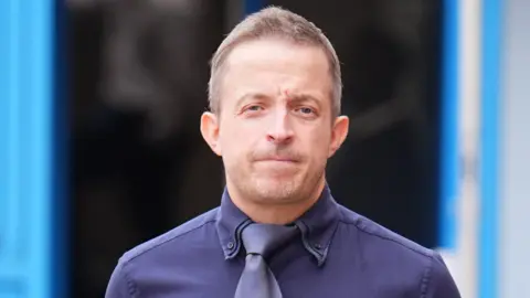 PA Media A photograph of Haden Pentecost wearing a blue shirt and tie. 