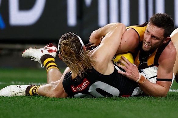 Jack Gunston of the Hawks and Darcy Moore of the Magpies in action.