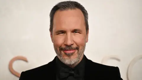 Getty Images Denis Villeneuve in a black shirt and smart jacket
