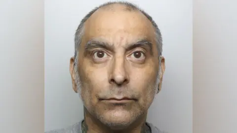 Thames Valley Police A mugshot photo featuring a man with large brown eyes and grey eyebrows, with short grey receding hair.