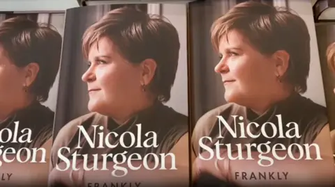 Books with Nicola Sturgeon in side profile. The words Nicola Sturgeon are in white letters, with Frankly written beneath her name