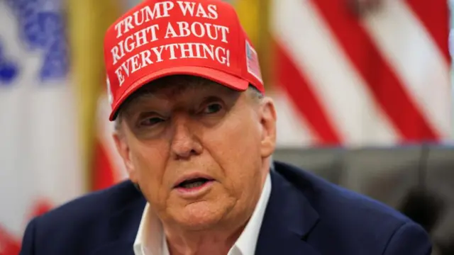 Donald Trump wears a red hat saying "Donald Trump was right about everything"