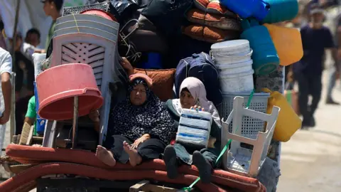 Reuters Displaced Palestinian women flee northern Gaza on a cart filled with their belongings, in Gaza City (21 August 2025)