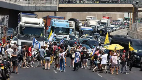 Getty Images Demonstrators block a road during a protest in Tel Aviv demanding a deal to release hostages detained in the Gaza Strip