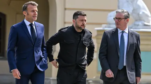 EPA France's President Emmanuel Macron, Ukraine's President Volodymyr Zelensky, and Britain's Prime Minister Keir Starmer walk together with Zelensky moving his hands