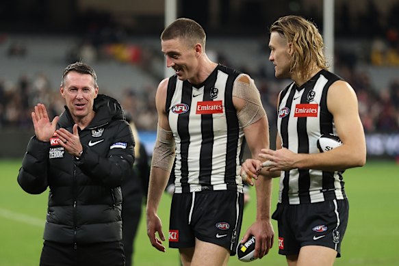 Craig McRae celebrates a thrilling win with Darcy Cameron and Darcy Moore.