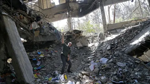 Getty Images A man stands amongst the ruins of a prison building in Iran