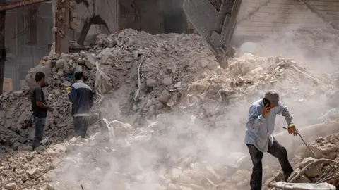 AFP via Getty Images Iranian workers amid the debris of a building targeted in Israeli attacks in Tehran, Iran, on August 16, 2025. 