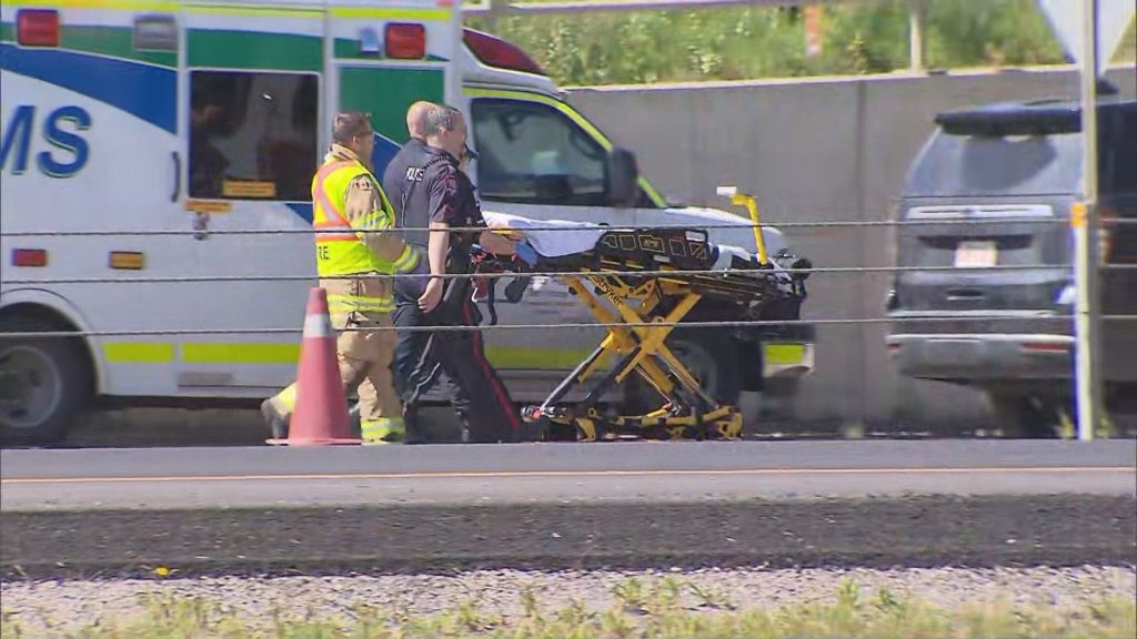 EMS with a stretcher at the scene of a crash on Deerfoot Trail SE in Calgary on Sunday, Aug. 17, 2025