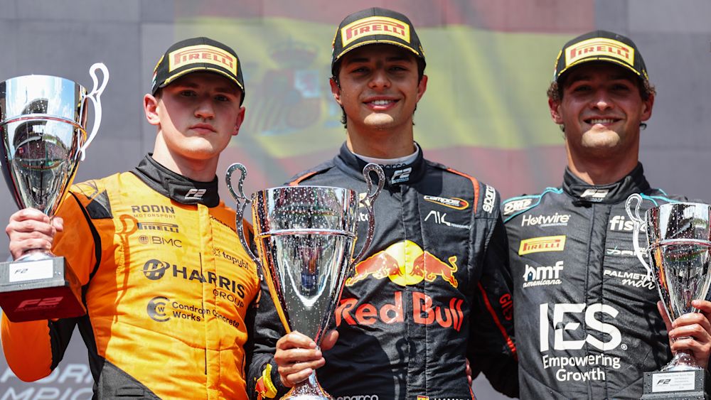 The top three celebrate on the podium after the race