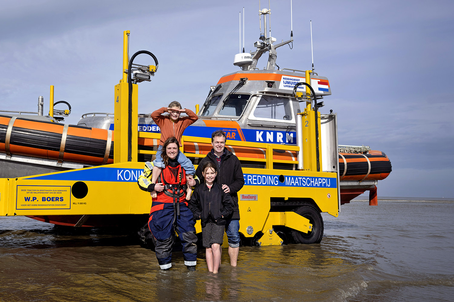 Image of Emilie Reuchlin with her family standing in the water next a docked boat.