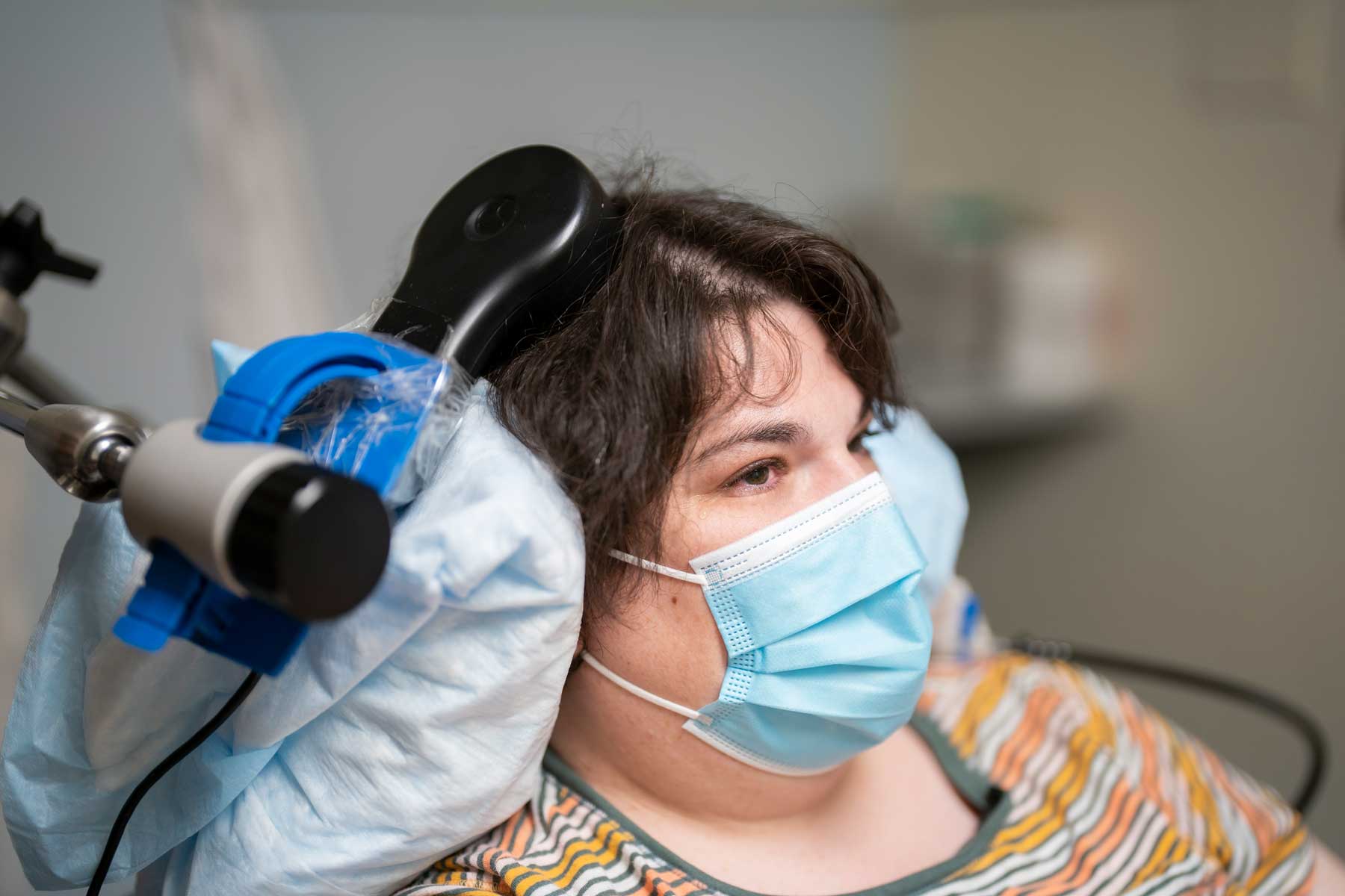 A patient named Sarah sits at a clinic to test out her deep brain stimulation device.