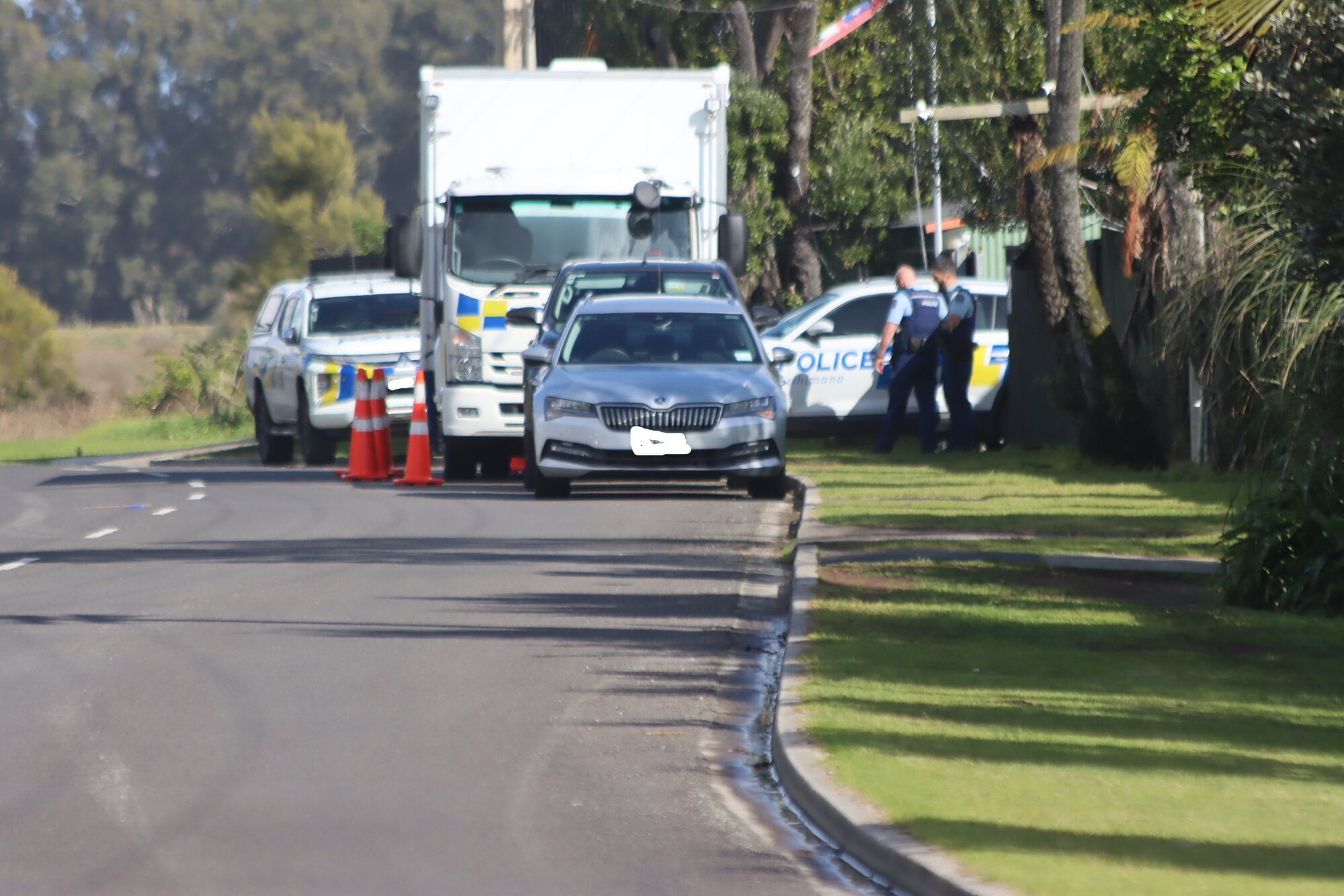 Police maintain a presence outside an address on Maketū Rd.  Photo / Tom Eley