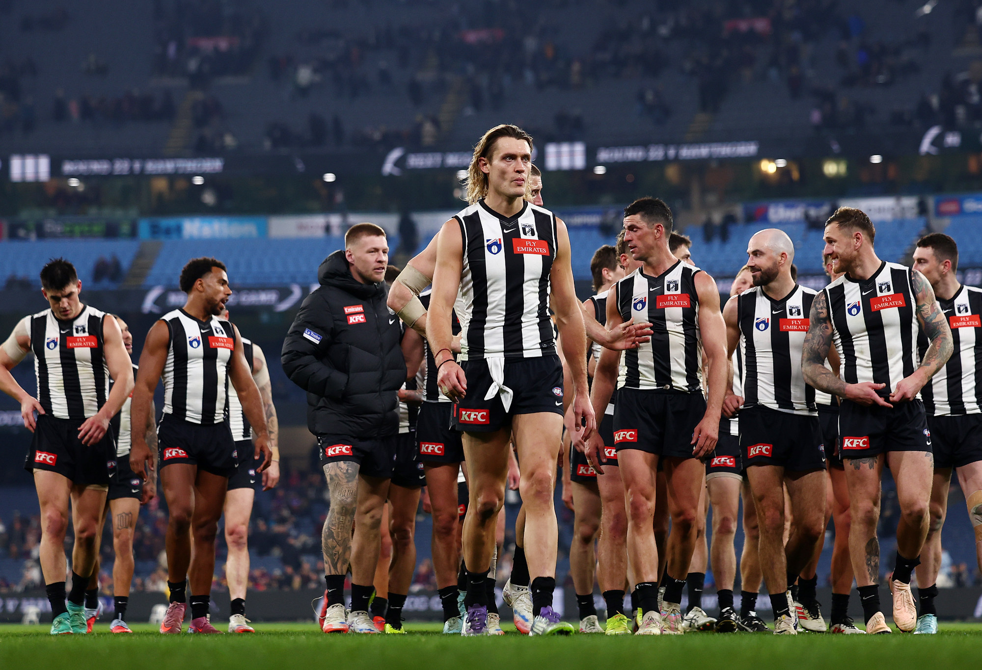 Darcy Moore leads Collingwood players from the MCG after their loss to Brisbane.