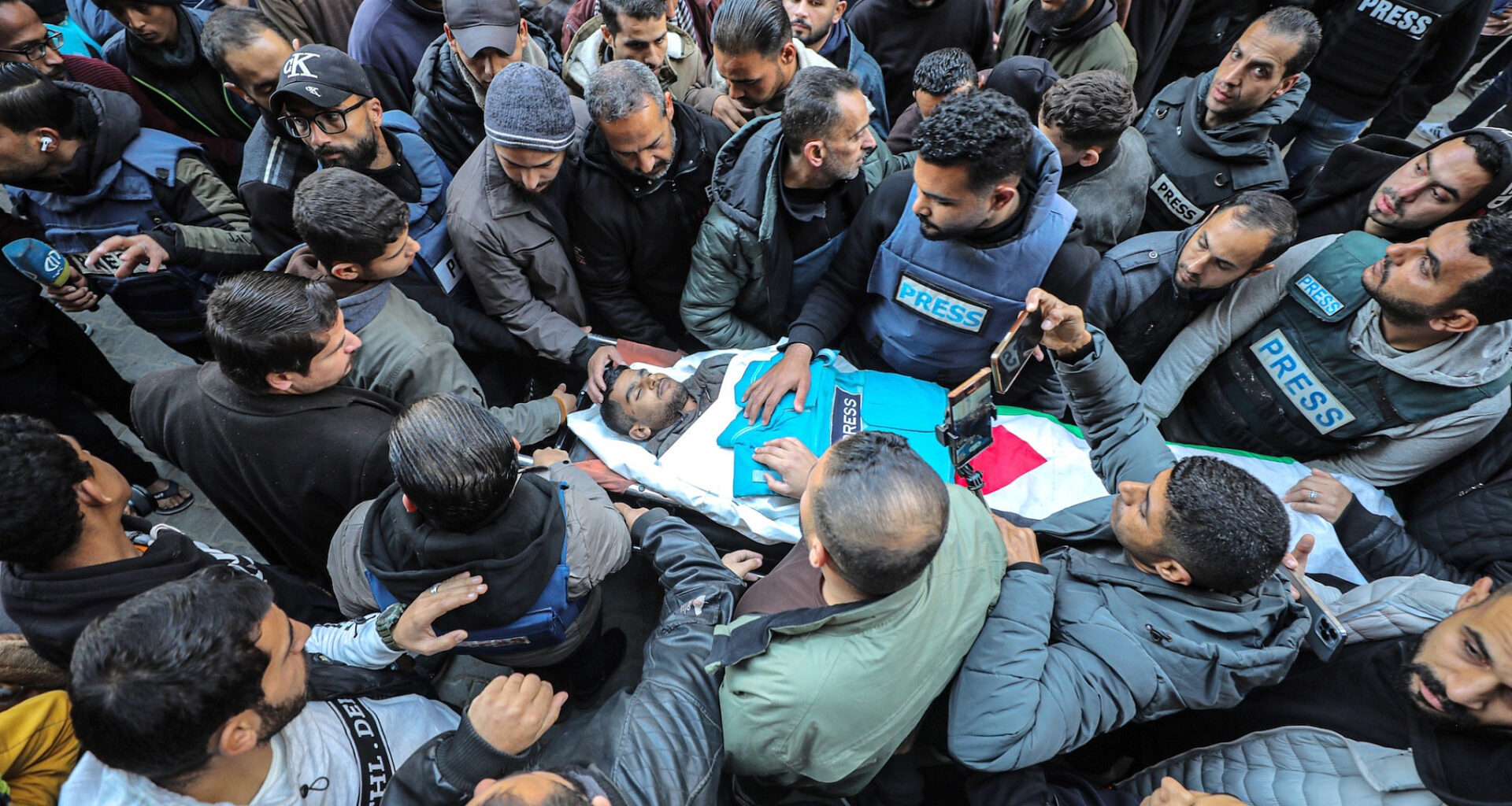 Family and friends mourn near the body of Palestinian journalist Saed Sabri Abu Nabhan, who was shot and killed by an Israeli army sniper, at Al Awda Hospital in northern Gaza, January 11, 2025. (Ali Hassan/Flash90)