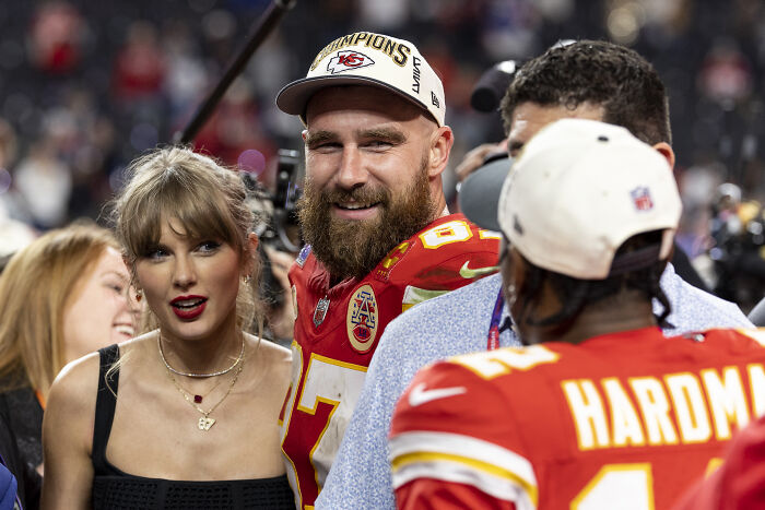 Travis Kelce celebrating with teammates on the field as Kayla Nicole sparks buzz after proposal to Taylor Swift.