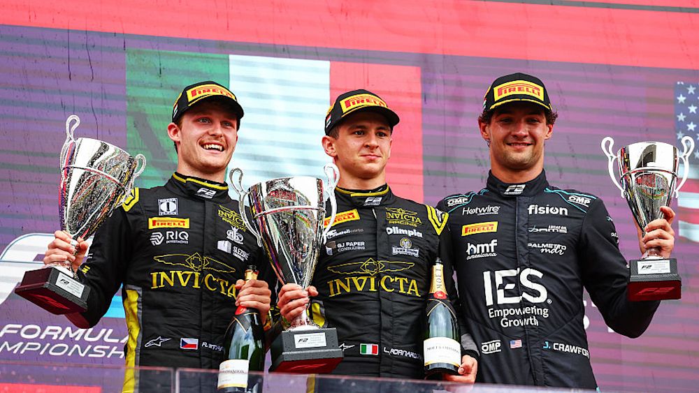 The top three celebrate on the podium after the race