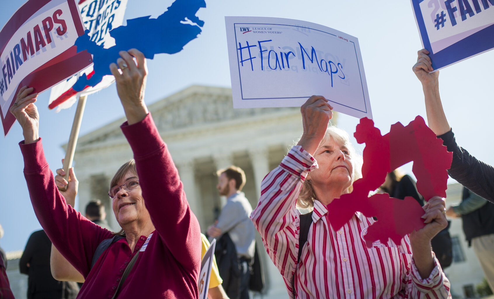 Shirley Connuck, right, holds up a sign representing a district in Texas, as the Supreme Court hears a case on partisan gerrymandering by state legislatures on October 3, 2017. (Photo By Tom Williams/Getty Images)
