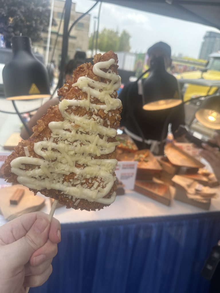 Deep-fried pizza on a stick with garlic sauce.