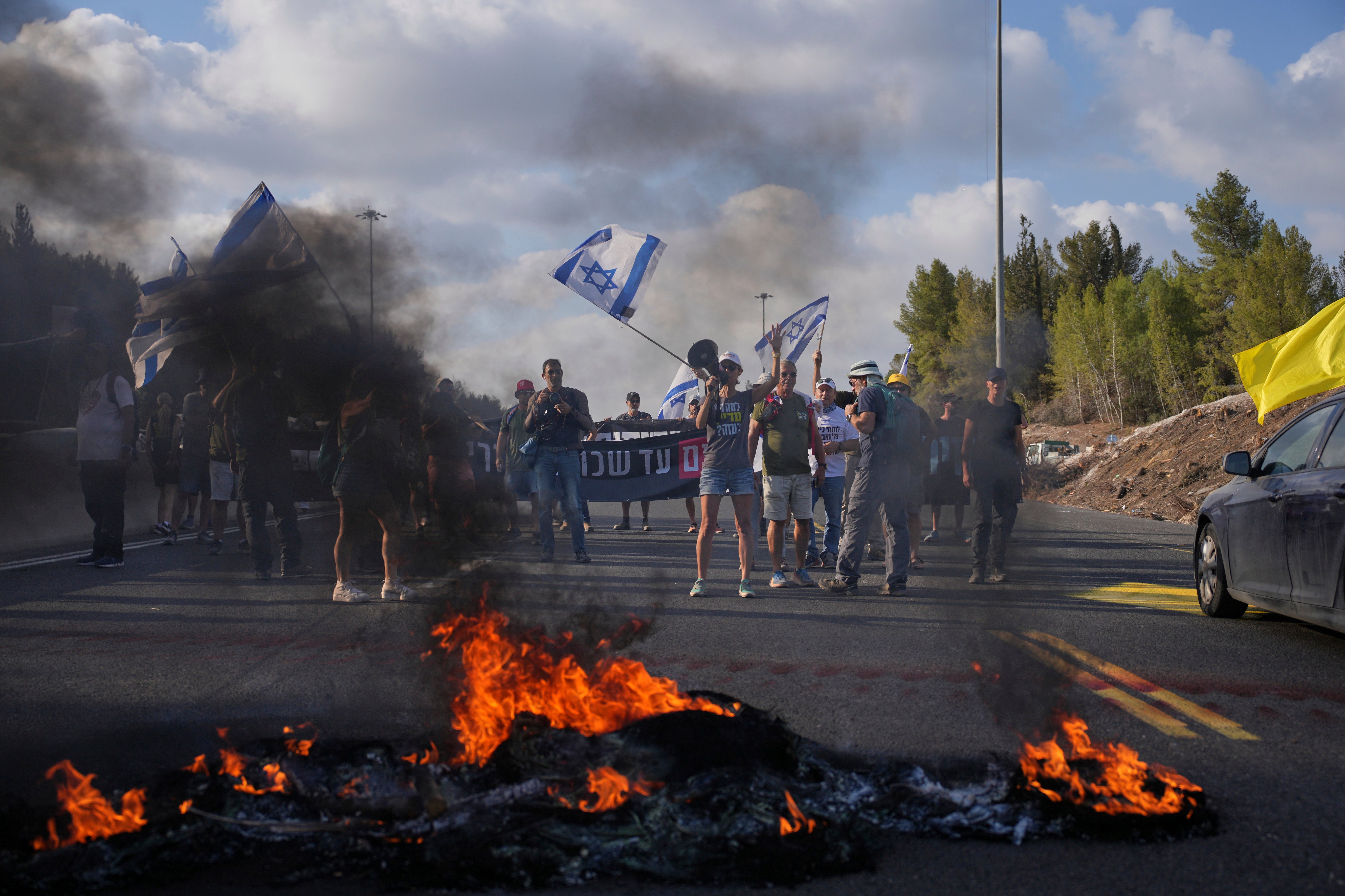 Demonstrators block a road during a protest demanding the immediate release of hostages held by Hamas and calling for the Israeli government to reverse its decision to take over Gaza City and other areas in the Gaza Strip, near Jerusalem, Israel, on Sunday
