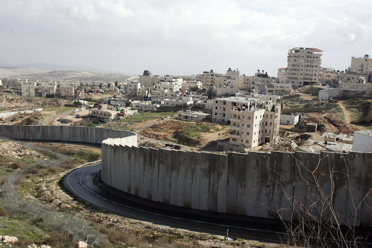 Israel’s separation barrier snakes between the hilltop East Jerusalem settlement of Pisgat Ze’ev and the Shuafat Palestinian refugee camp, in 2011. (Photo: Mahfouz Abu Turk/APA Images)