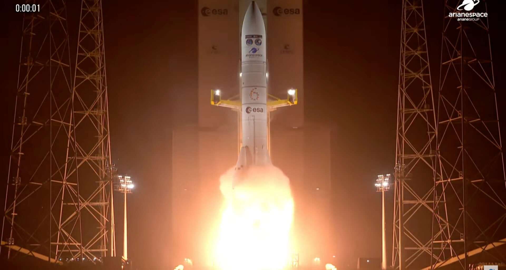 a big white rocket launches into a dark night sky